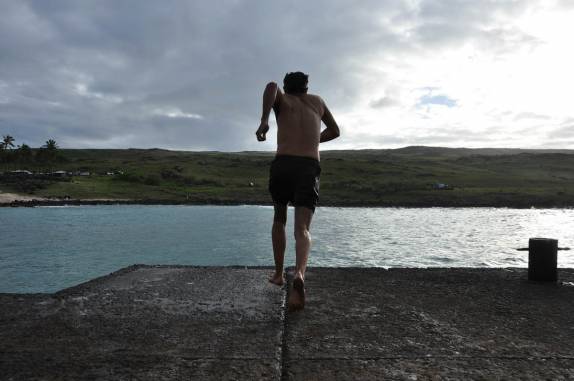 Correndo para saltar no mar na praia de Anakena, em Rapa Nui (ou Ilha de Páscoa), ilha chilena no meio do Oceano Pacífico